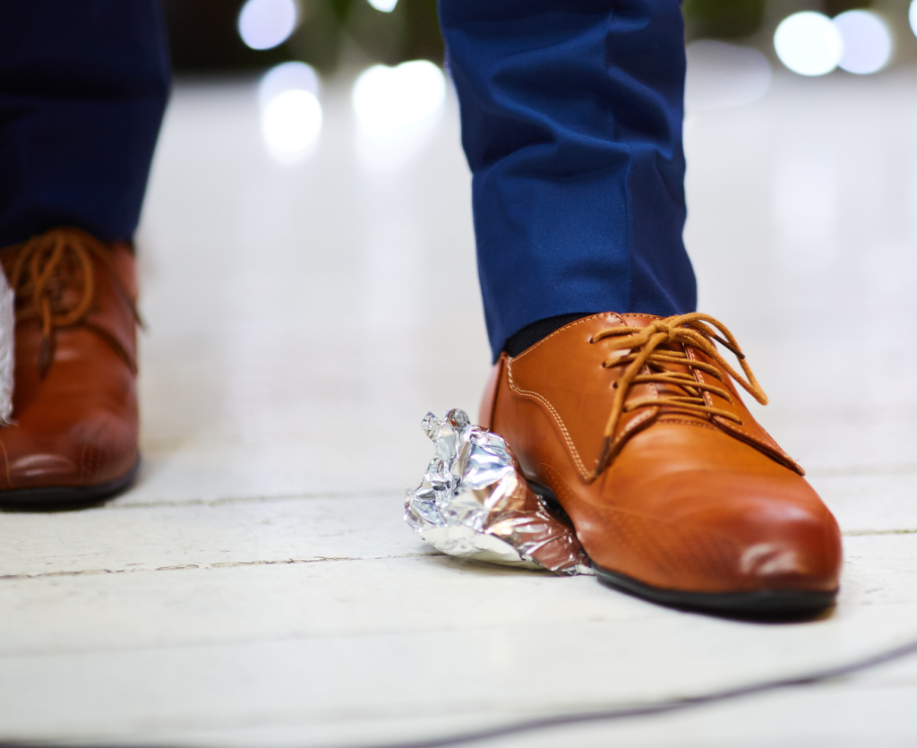 Man breaking glass with his foot at a wedding.